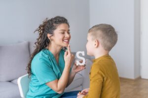 Speech therapist working with young boy during ABA therapy session