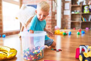 young child with autism playing in a sensory bin