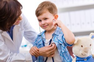 pediatrician examining a young boy